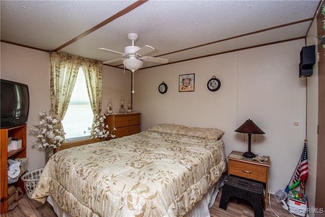 bedroom featuring crown molding, ceiling fan, hardwood / wood-style floors, and a textured ceiling