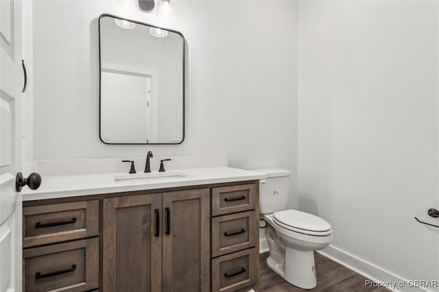 8280 Mobjack Ln, Hayes, VA 23072 - half bath with toilet, wood finished floors, vanity, and baseboards