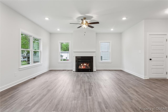 8280 Mobjack Ln, Hayes, VA 23072 - unfurnished living room featuring a fireplace with flush hearth, wood finished floors, plenty of natural light, and a ceiling fan