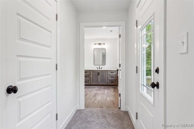 8280 Mobjack Ln, Hayes, VA 23072 - corridor featuring a sink, carpet flooring, and baseboards