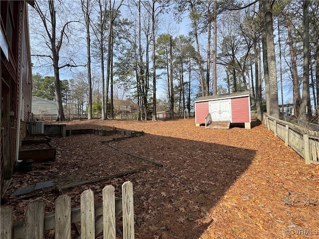 view of yard with an outbuilding, fence, central AC unit, and a storage unit