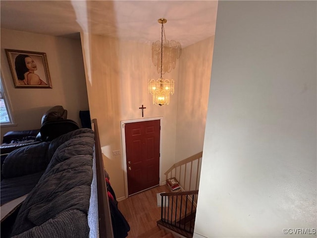 foyer entrance featuring stairs, a chandelier, and wood finished floors