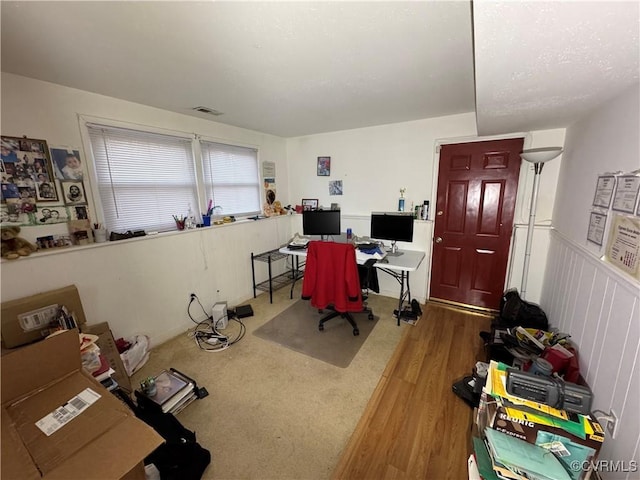 office with wainscoting, wood finished floors, and visible vents