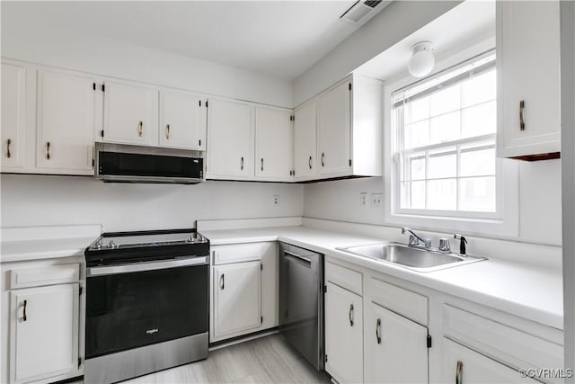 kitchen with sink, white cabinets, and appliances with stainless steel finishes