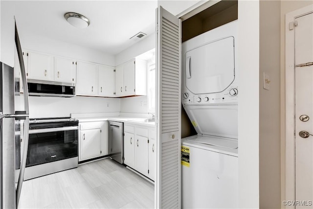 clothes washing area with sink and stacked washer and clothes dryer