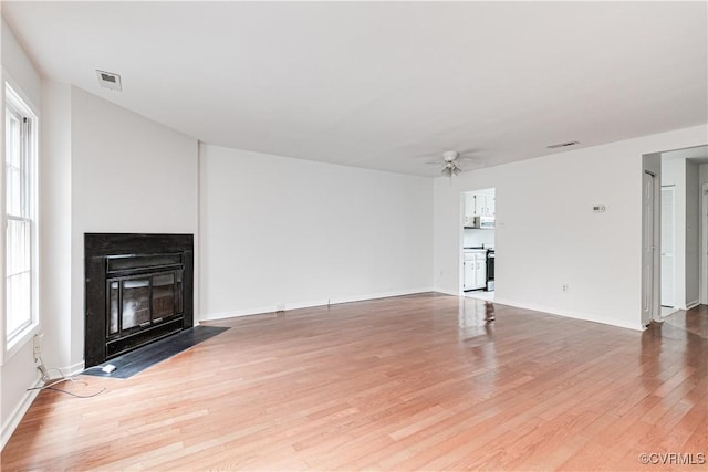 unfurnished living room featuring ceiling fan, a healthy amount of sunlight, and light hardwood / wood-style floors