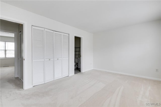 unfurnished bedroom with light carpet and a closet