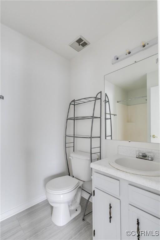 bathroom with vanity, walk in shower, and toilet