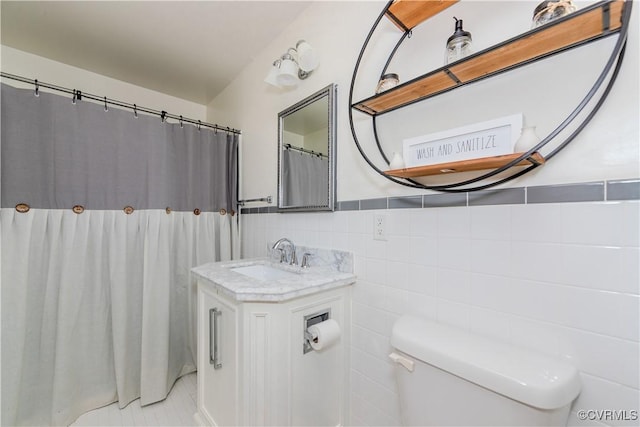 bathroom featuring tile walls, vanity, and toilet