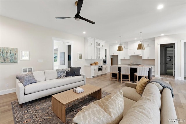 living room featuring ceiling fan and light hardwood / wood-style floors