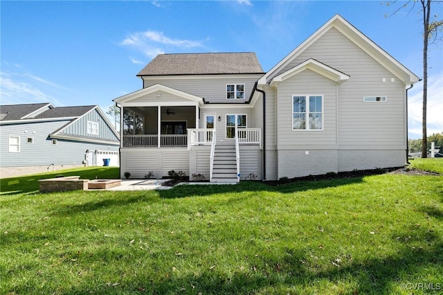 rear view of house featuring ceiling fan, a sunroom, and a lawn