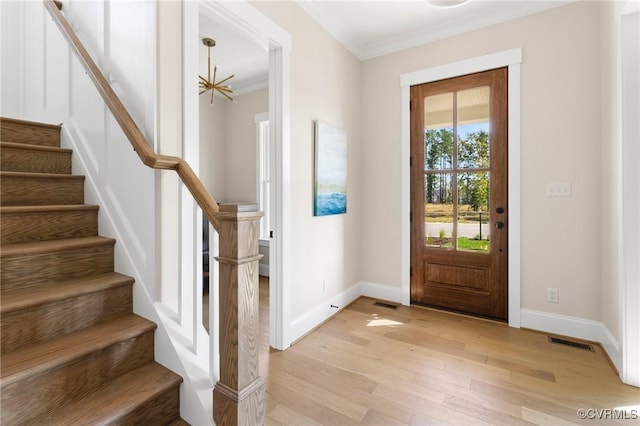 foyer with ornamental molding and light wood-type flooring