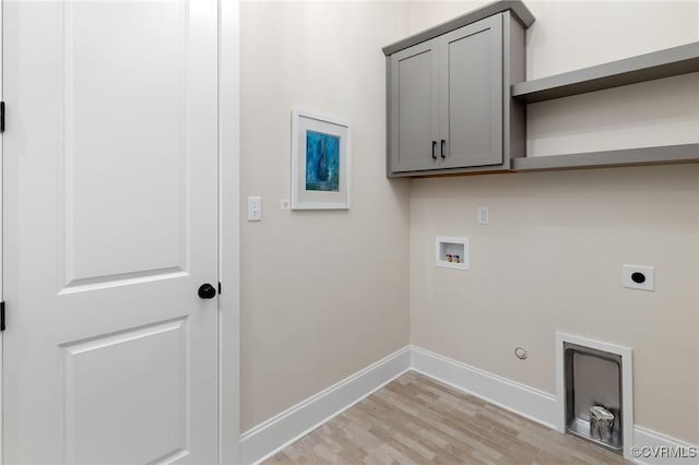 washroom featuring cabinets, washer hookup, hookup for a gas dryer, hookup for an electric dryer, and light wood-type flooring