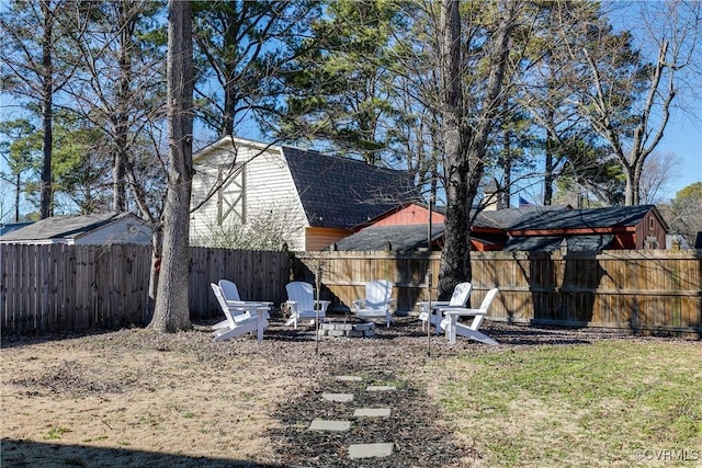 view of yard featuring a fenced backyard and a fire pit