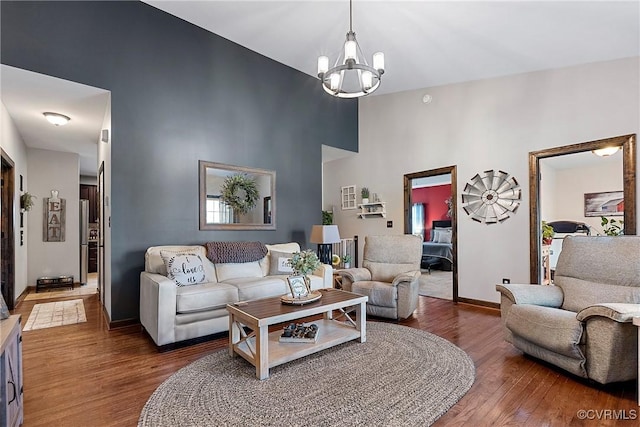 living room featuring a towering ceiling, dark hardwood / wood-style floors, and a chandelier