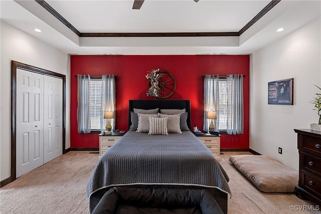 bedroom with light colored carpet, ornamental molding, and a raised ceiling