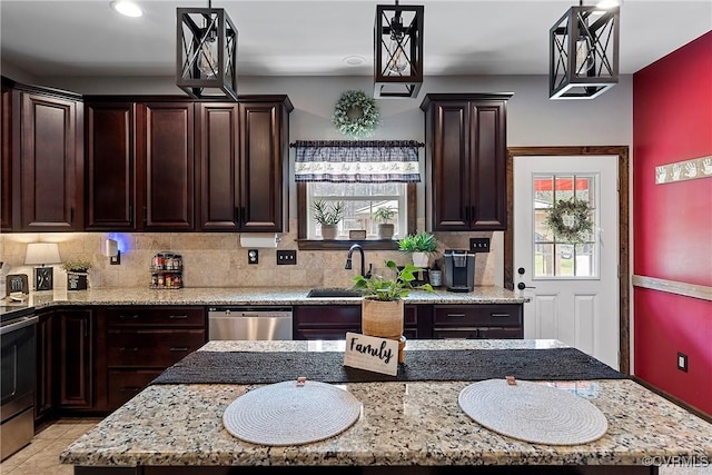 kitchen featuring sink, decorative light fixtures, a kitchen island, a wealth of natural light, and stainless steel appliances