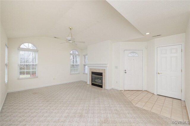 unfurnished living room with vaulted ceiling, light colored carpet, ceiling fan, and a fireplace