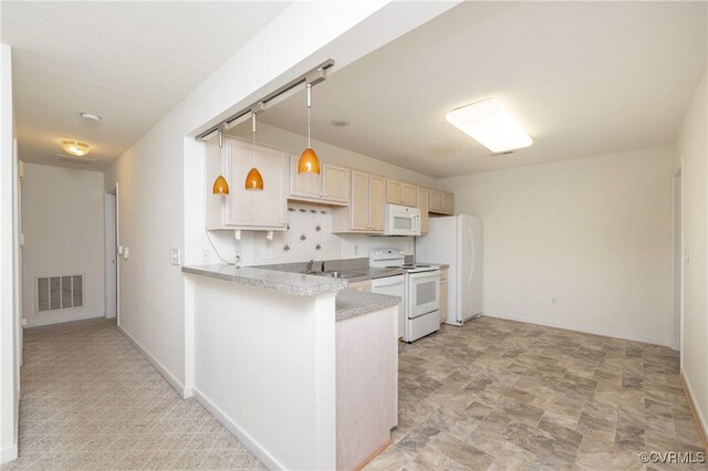 kitchen with pendant lighting, sink, white appliances, and kitchen peninsula