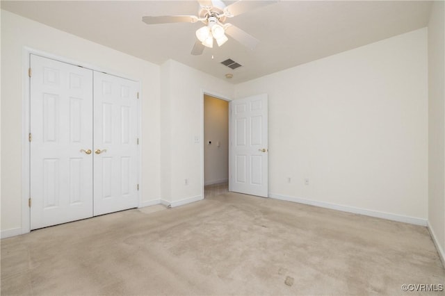 unfurnished bedroom with light colored carpet, ceiling fan, and a closet