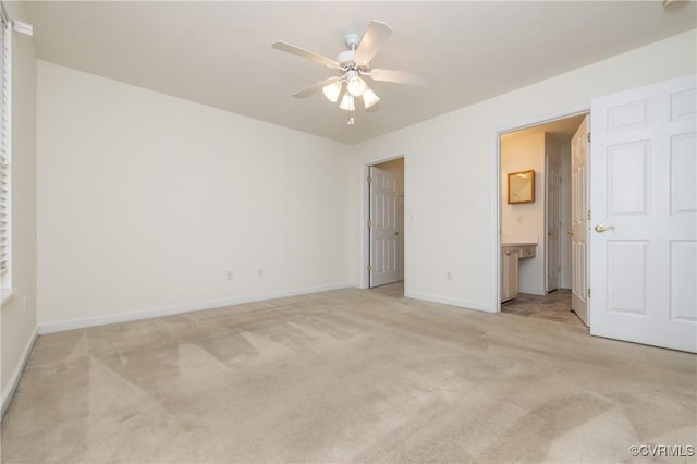 unfurnished bedroom with ceiling fan, light carpet, and ensuite bath