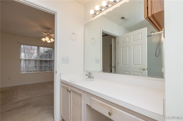 bathroom featuring vanity, a shower with shower door, and ceiling fan