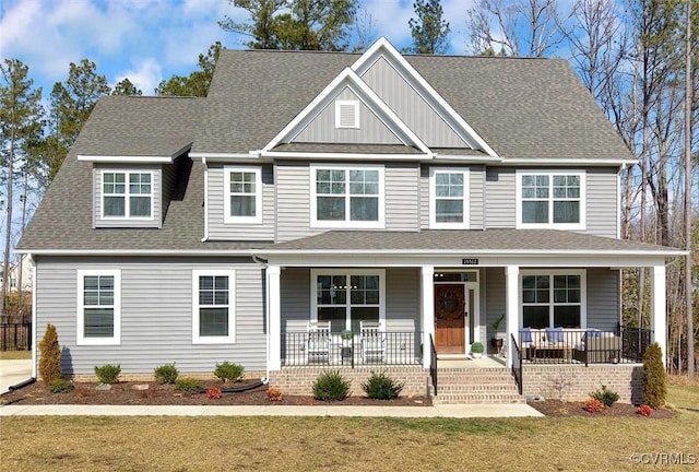 view of front of house featuring a porch, a front yard, and a shingled roof