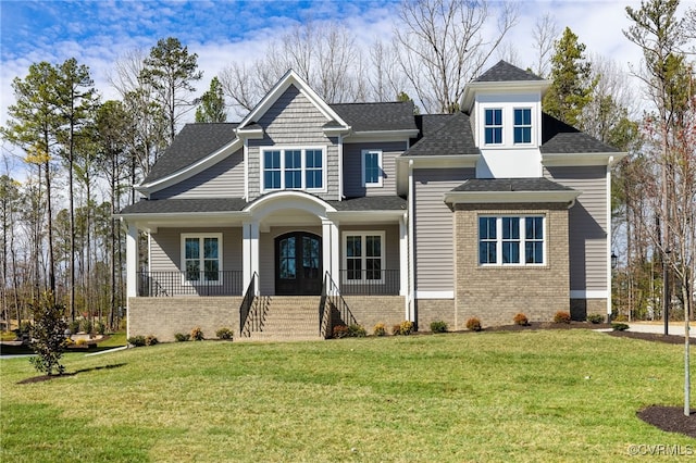 view of front of home with a front yard, covered porch, and french doors