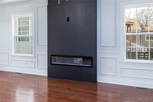 details with wood-type flooring and a large fireplace