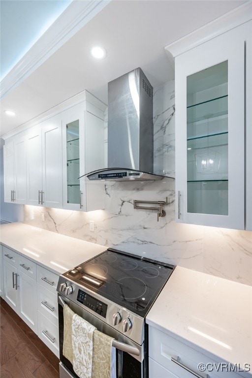 kitchen with wall chimney range hood, electric range, white cabinets, dark hardwood / wood-style flooring, and decorative backsplash