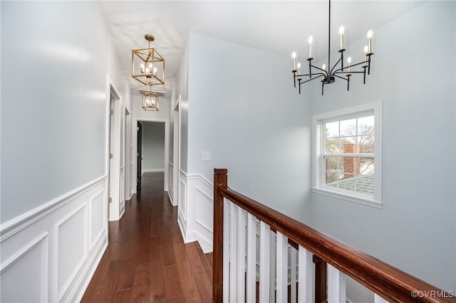 hallway featuring an inviting chandelier and dark hardwood / wood-style floors