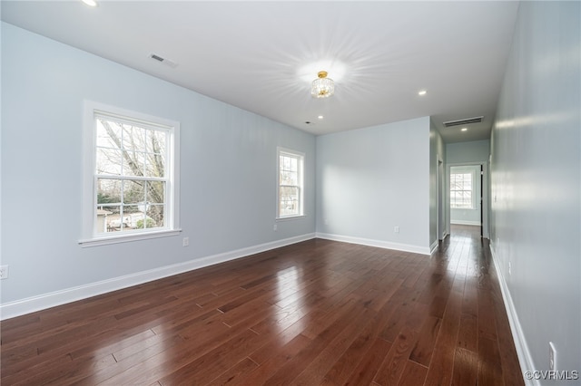 unfurnished room with recessed lighting, baseboards, visible vents, and dark wood-style floors