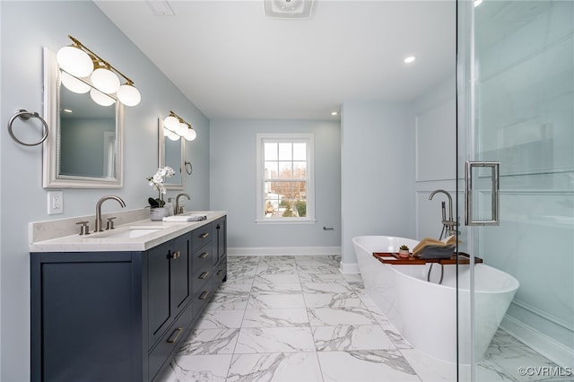 full bathroom with a sink, a freestanding bath, double vanity, and marble finish floor
