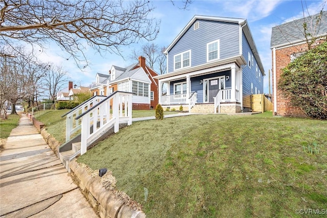 view of front of home featuring fence, a porch, and a front lawn