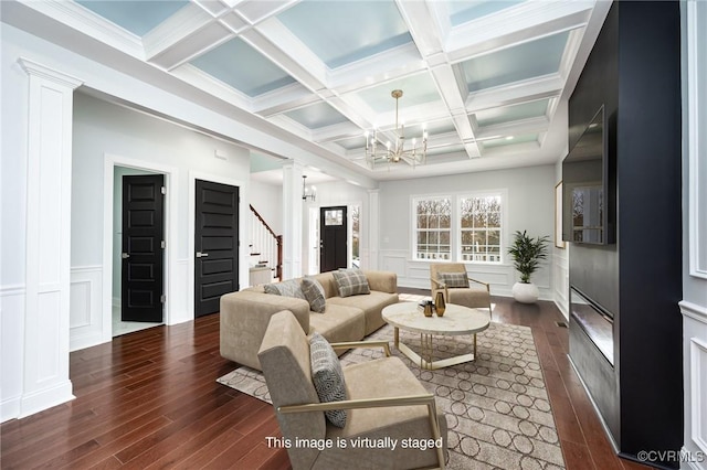 living area featuring decorative columns, beam ceiling, stairway, coffered ceiling, and dark wood-type flooring