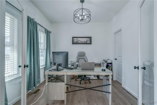 office area featuring french doors, a chandelier, and light hardwood / wood-style flooring