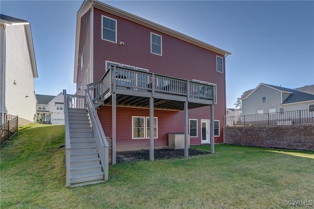 rear view of property with a wooden deck and a lawn