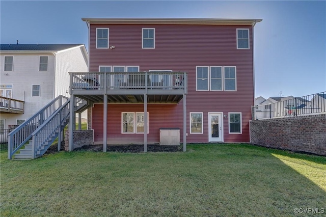 rear view of property featuring a wooden deck and a yard