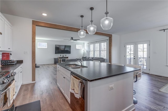 kitchen with white cabinetry, an island with sink, sink, hanging light fixtures, and stainless steel appliances