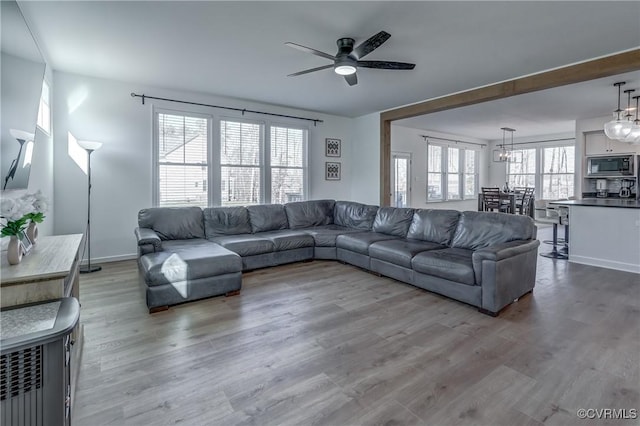 living room featuring wood-type flooring and ceiling fan with notable chandelier