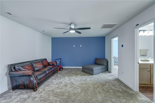 carpeted living room with ceiling fan