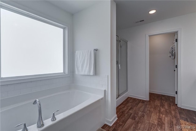 bathroom featuring wood-type flooring and separate shower and tub