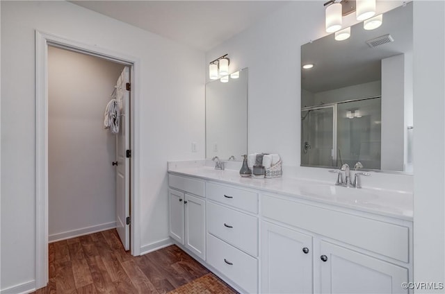 bathroom with vanity, hardwood / wood-style flooring, and a shower with shower door