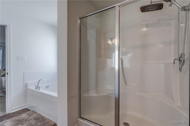 bathroom featuring plus walk in shower and hardwood / wood-style floors