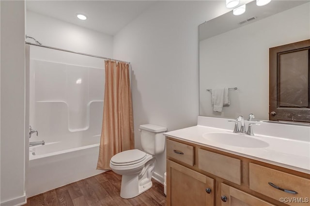 full bathroom with shower / bathtub combination with curtain, hardwood / wood-style floors, vanity, and toilet