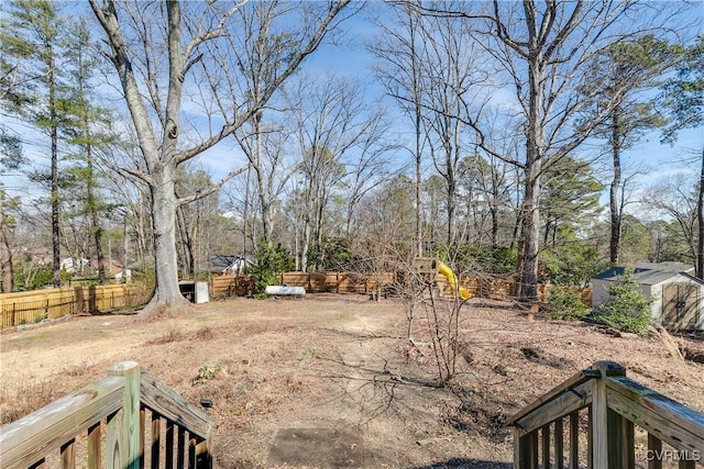 view of yard with an outbuilding, fence, and a storage shed