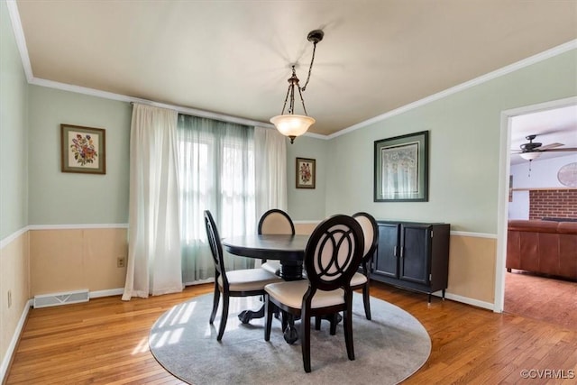 dining space with light hardwood / wood-style flooring and crown molding