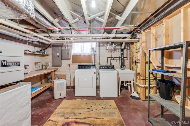 below grade area featuring a sink, electric panel, and washer and dryer