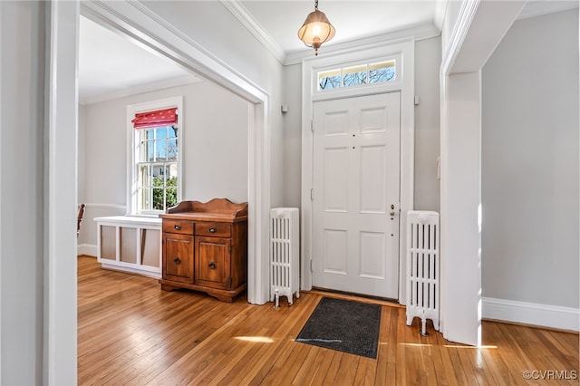 foyer featuring ornamental molding, radiator, and wood-type flooring