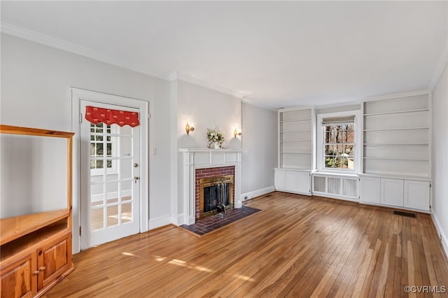 unfurnished living room with light wood-type flooring, radiator, visible vents, and crown molding